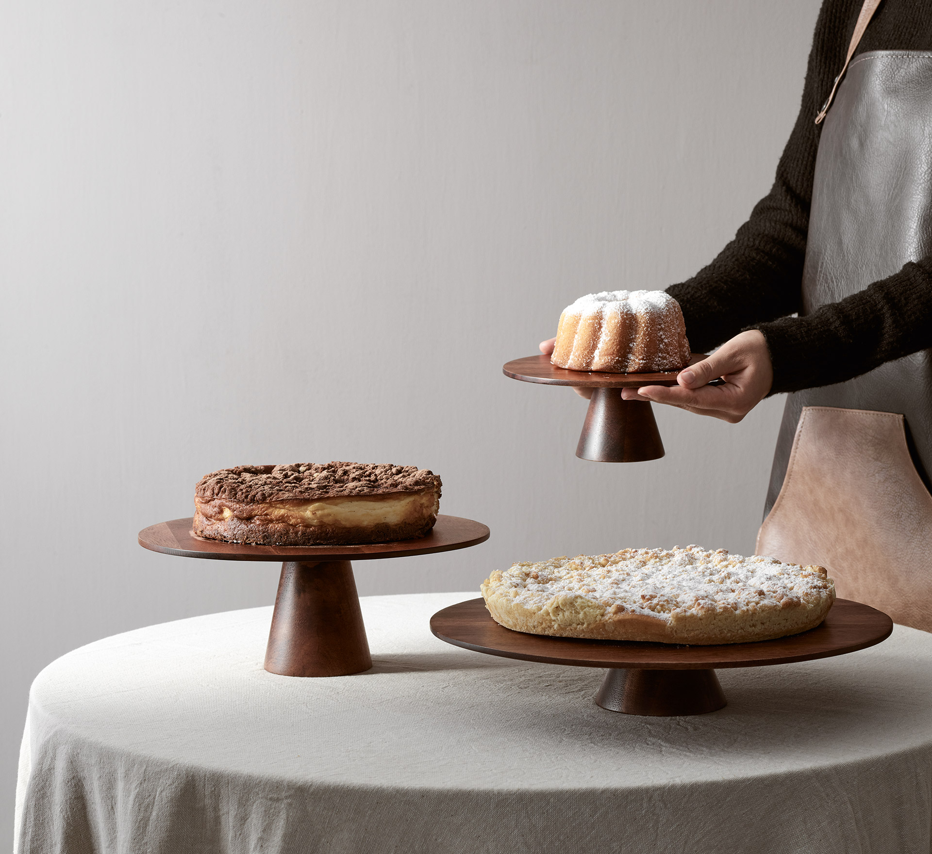 Auf dem Bild ist ein hölzerner Foodstand mit Kuchen zu sehen. Es ist eine Präsentation für kulinarische Speisen.