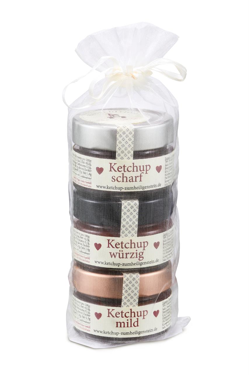 Das Bild zeigt drei kleine Gläser Ketchup in einer transparenten Geschenkverpackung. Die Sorten sind scharf, würzig und mild, jeweils mit 75g Inhalt.