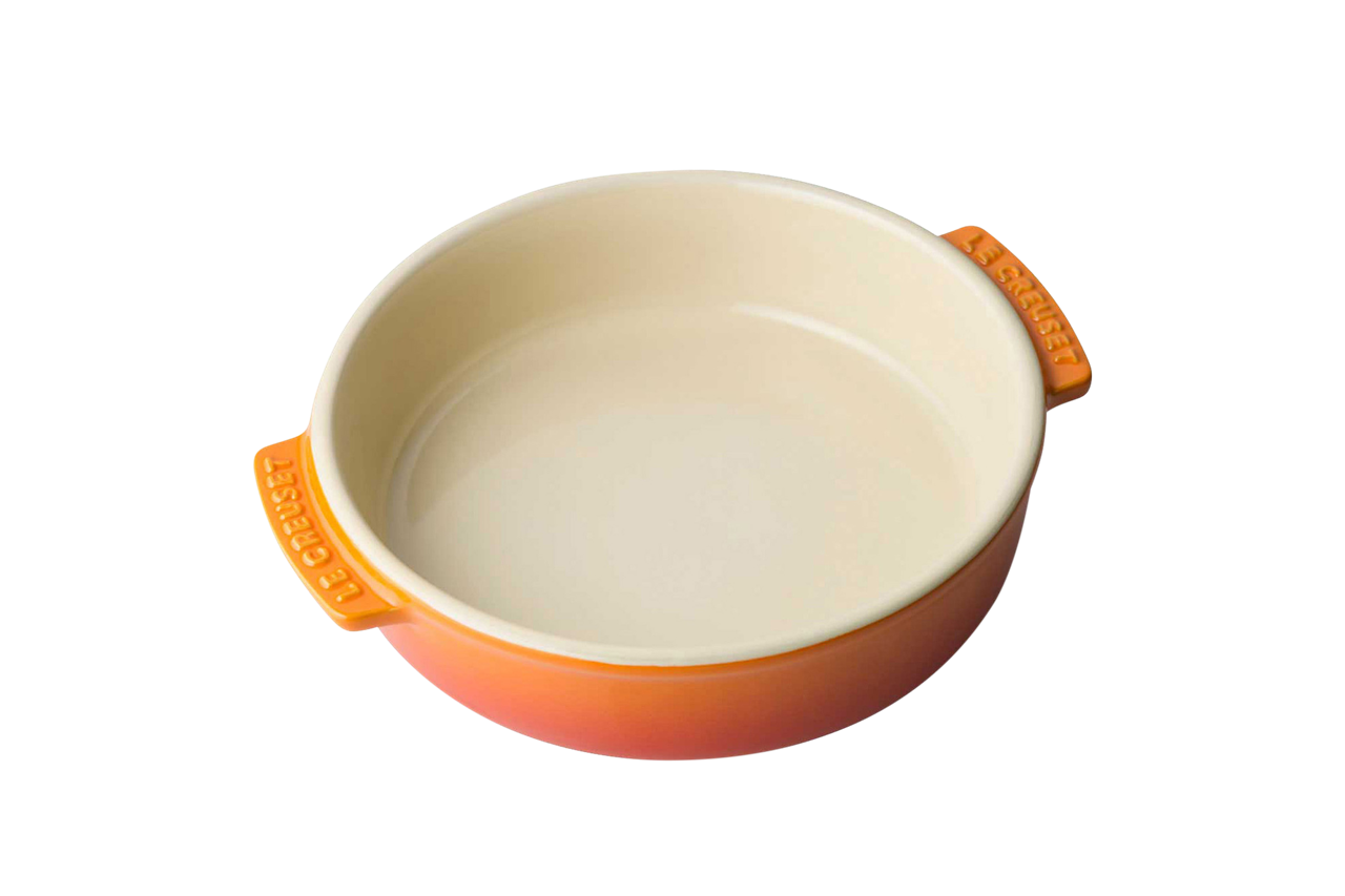 Die Abbildung zeigt eine runde Tapasschale in der Farbe Ofenrot. Die Schale hat zwei Griffe mit dem Schriftzug "Le Creuset".