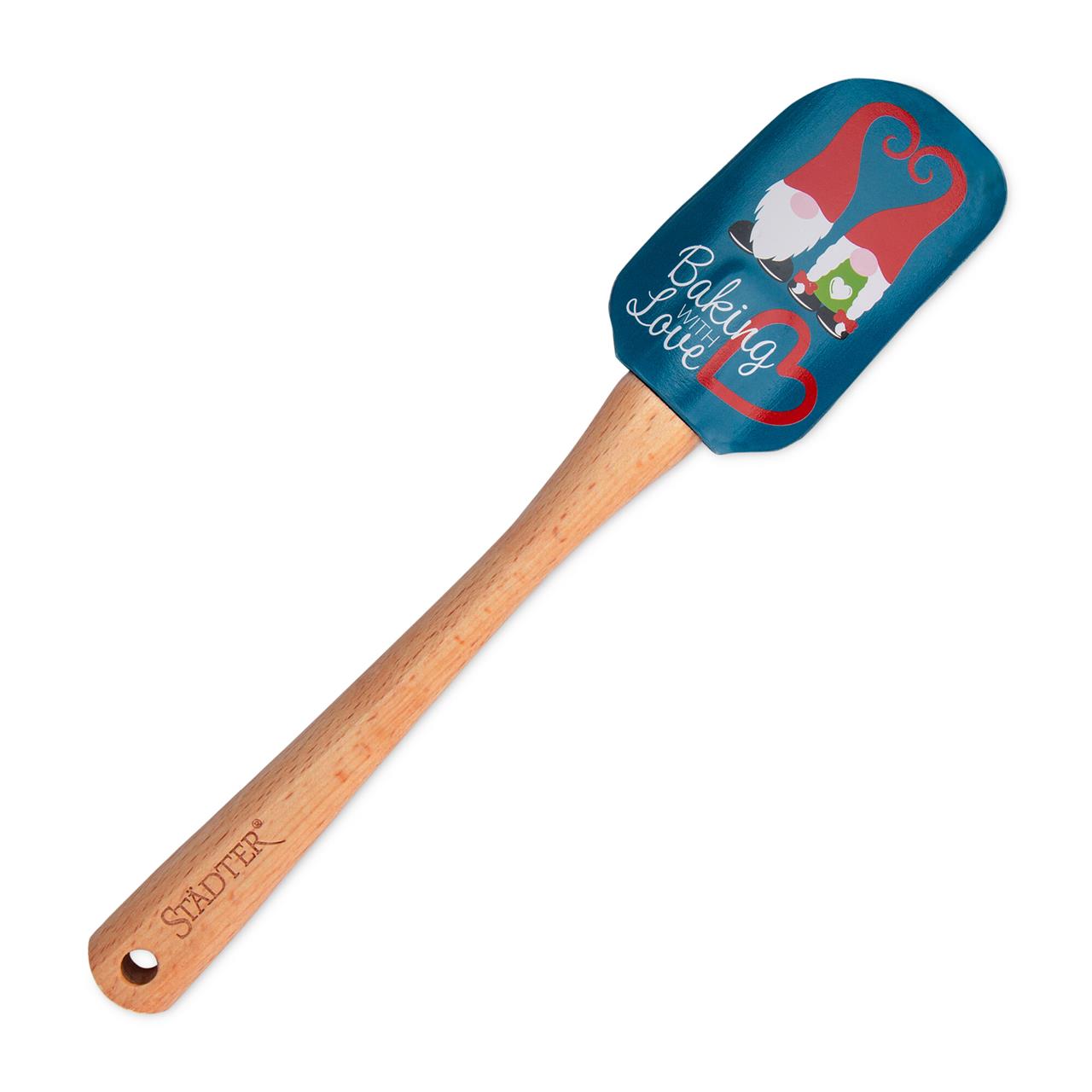 Der Teigschaber Wichtel hat einen Holzgriff und eine blaue Silikonfläche mit zwei Wichteln darauf. Auf dem Schaber steht der Text "Baking with Love".