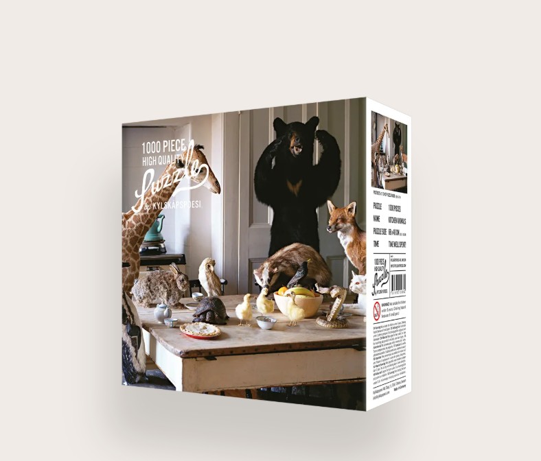 Das Bild zeigt das Produkt 'Puzzle Kitchen Animals 1000 Teile'. Dieses Puzzle besteht aus 1000 Teilen und zeigt verschiedene Tiere in einer Küche.