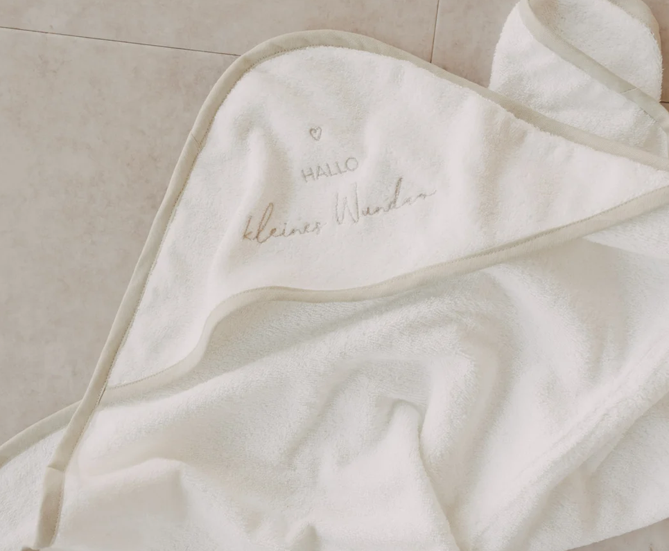Handtuch mit Kapuze Kleines Wunder ist abgebildet. Das Handtuch hat eine Kapuze und ist für Babys geeignet.