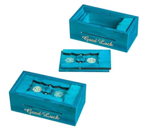 Auf dem Bild sind drei türkisfarbene Holzkästchen zu sehen. Auf jedem Kästchen steht in goldener Schrift "Good Luck".