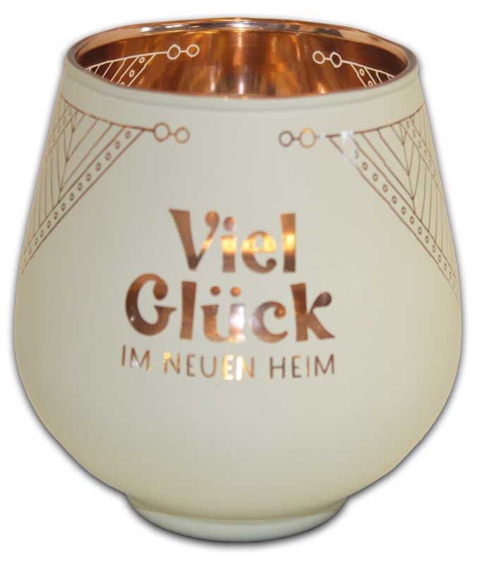 Das Bild zeigt ein Windlicht mit der Aufschrift "Viel Glück im neuen Heim". Das Windlicht ist cremefarben mit goldenen Verzierungen und einem goldenen Innenrand.