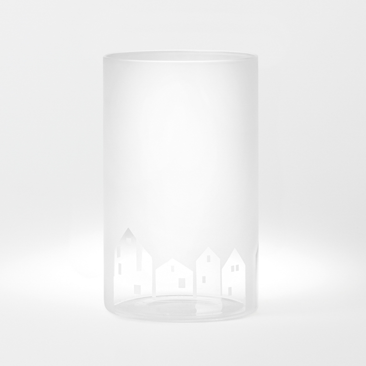 Auf dem Bild ist ein durchsichtiges Glas mit mattem Finish zu sehen. Am unteren Rand des Glases sind kleine Häuser als Muster eingraviert.