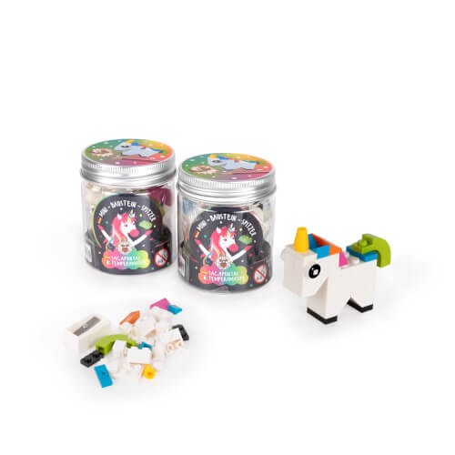 Auf dem Bild sind zwei Dosen mit Einhorn-Bausteinen zu sehen. Daneben liegen einige bunte Bausteine und ein gebautes Einhorn.