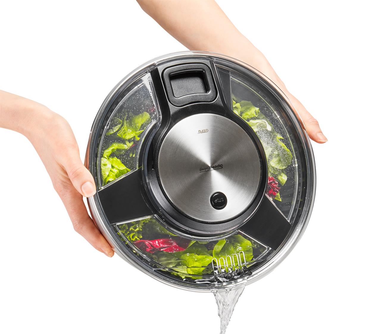 Eine Person hält eine Salatschleuder SPEEDWING® aus Edelstahl und gießt Wasser ab. Im Inneren befinden sich frische Salatblätter.
