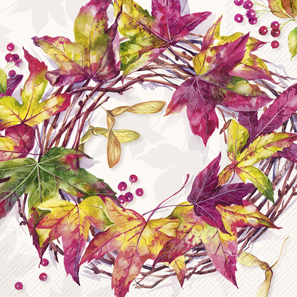 Das Bild zeigt eine herbstliche Serviette mit einem bunten Kranz aus Blättern und Zweigen. Die Farben der Blätter sind gelb, rot und grün, und es sind kleine rote Beeren zu sehen.
