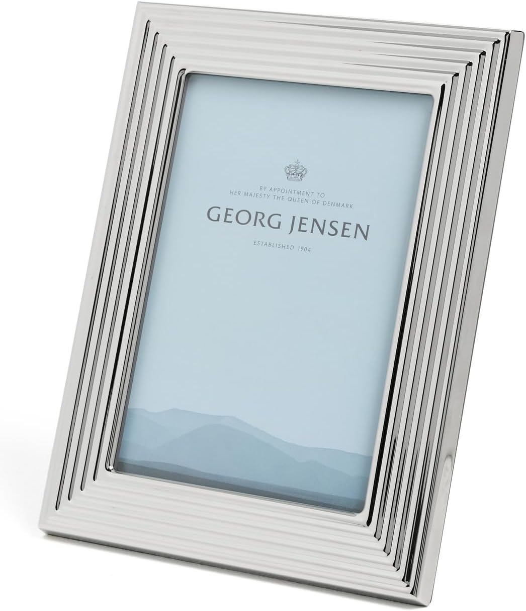 Dies ist ein Bernadotte Bilderrahmen aus Kunststoff und Edelstahl im Spiegel-Design, Größe 13x18. Der Bilderrahmen wirkt elegant und modern.