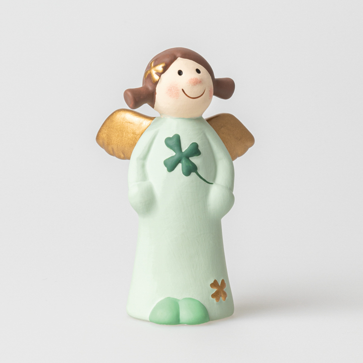 Die Figur zeigt einen lächelnden Engel mit goldenen Flügeln und einem vierblättrigen Kleeblatt auf dem Kleid. Sie trägt ein mintgrünes Gewand und hat braune Haare mit einem kleinen gelben Stern.