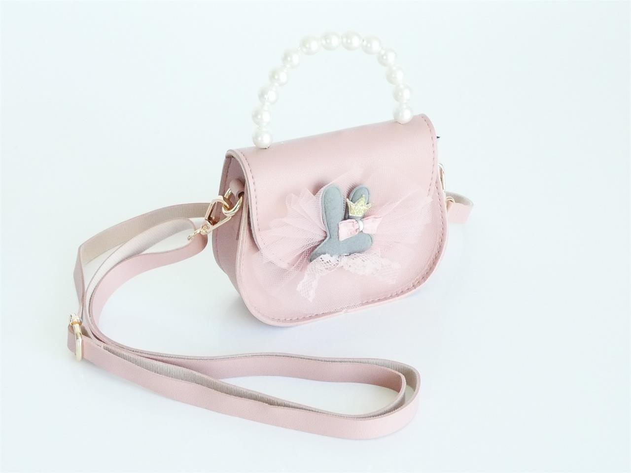 Die Umhängetasche ist in Altrosa gehalten und hat einen Henkel aus Perlen. Sie ist mit Tüll und einer niedlichen Verzierung auf der Vorderseite dekoriert.