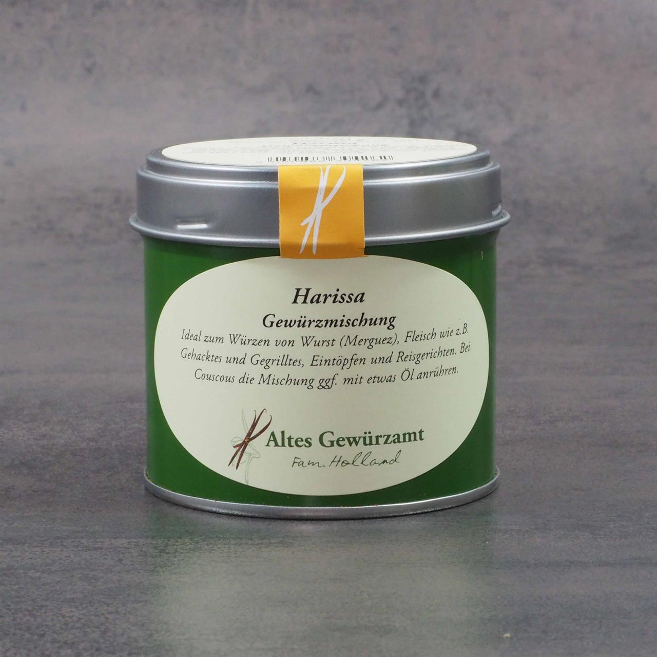 Auf dem Bild ist eine grüne Dose mit der Aufschrift "Harissa Gewürzmischung 70g" zu sehen. Die Dose stammt von der Marke "Altes Gewürzamt" und steht auf einer grauen Oberfläche.