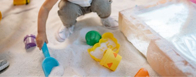 Das Bild zeigt einen Sandkasten. Der Sandkasten ist aus Holz und eignet sich ideal zum Spielen für Kinder.
