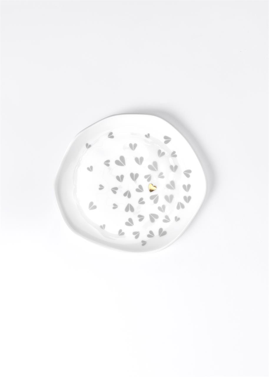 Der kleine Teller hat ein Durchmesser von 14 cm und ist mit grauen Herzmustern verziert. In der Mitte befindet sich ein einzelnes, goldenes Herz.
