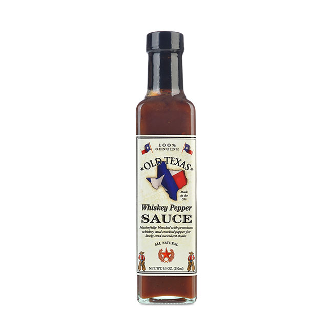Auf dem Bild ist eine Flasche „Old Texas Whiskey Pepper Steak Sauce“ mit 250 ml Inhalt zu sehen. Die Flasche hat ein rechteckiges Etikett mit dem Umriss von Texas und der Aufschrift „Whiskey Pepper Sauce“.