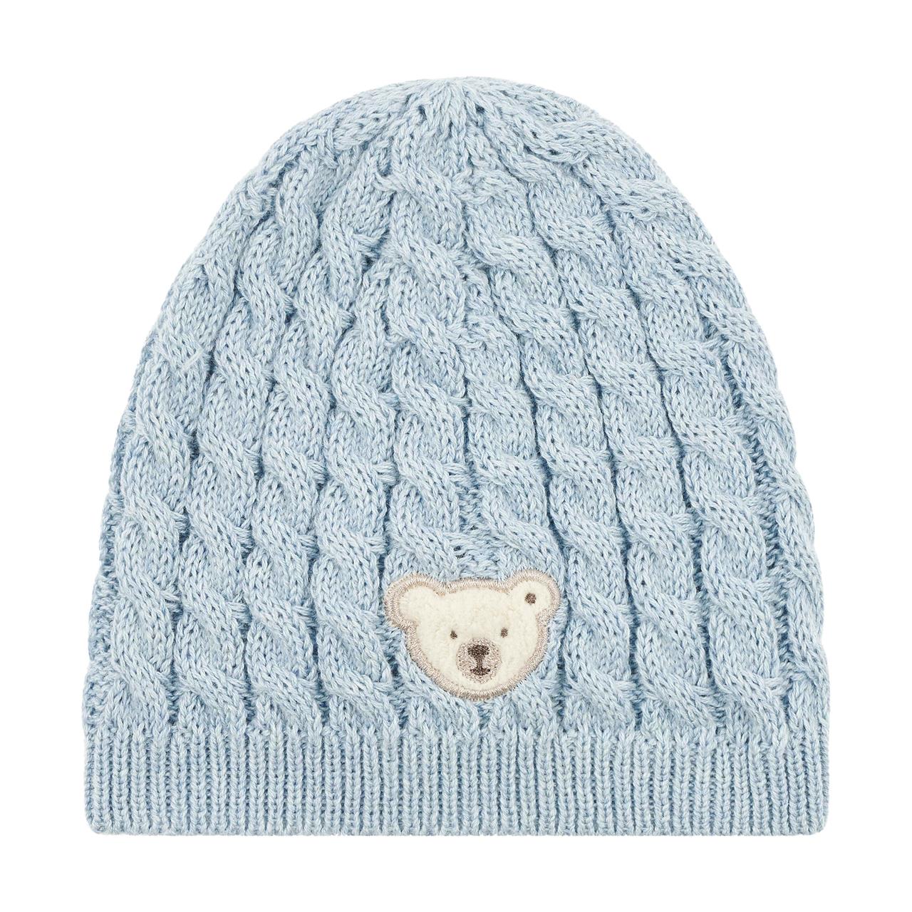 Die Abbildung zeigt eine gestrickte, hellblaue Mütze mit Zopfmuster. Vorne ist ein kleiner Bärenkopf als Aufnäher zu sehen.