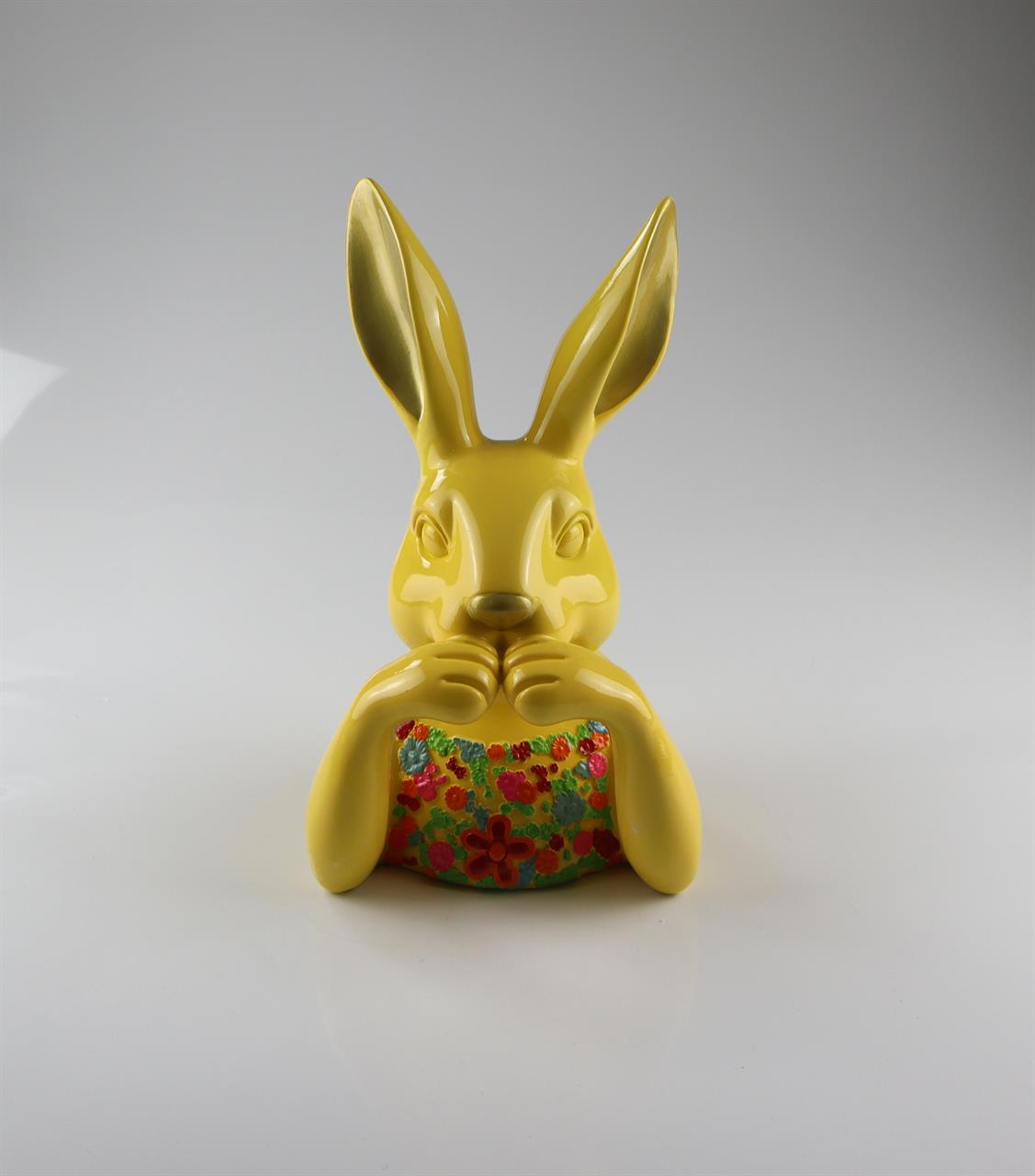 Auf dem Bild ist eine gelbe Hasenfigur zu sehen. Der Hase hält bunte Blumen und ist etwa 23 cm groß.