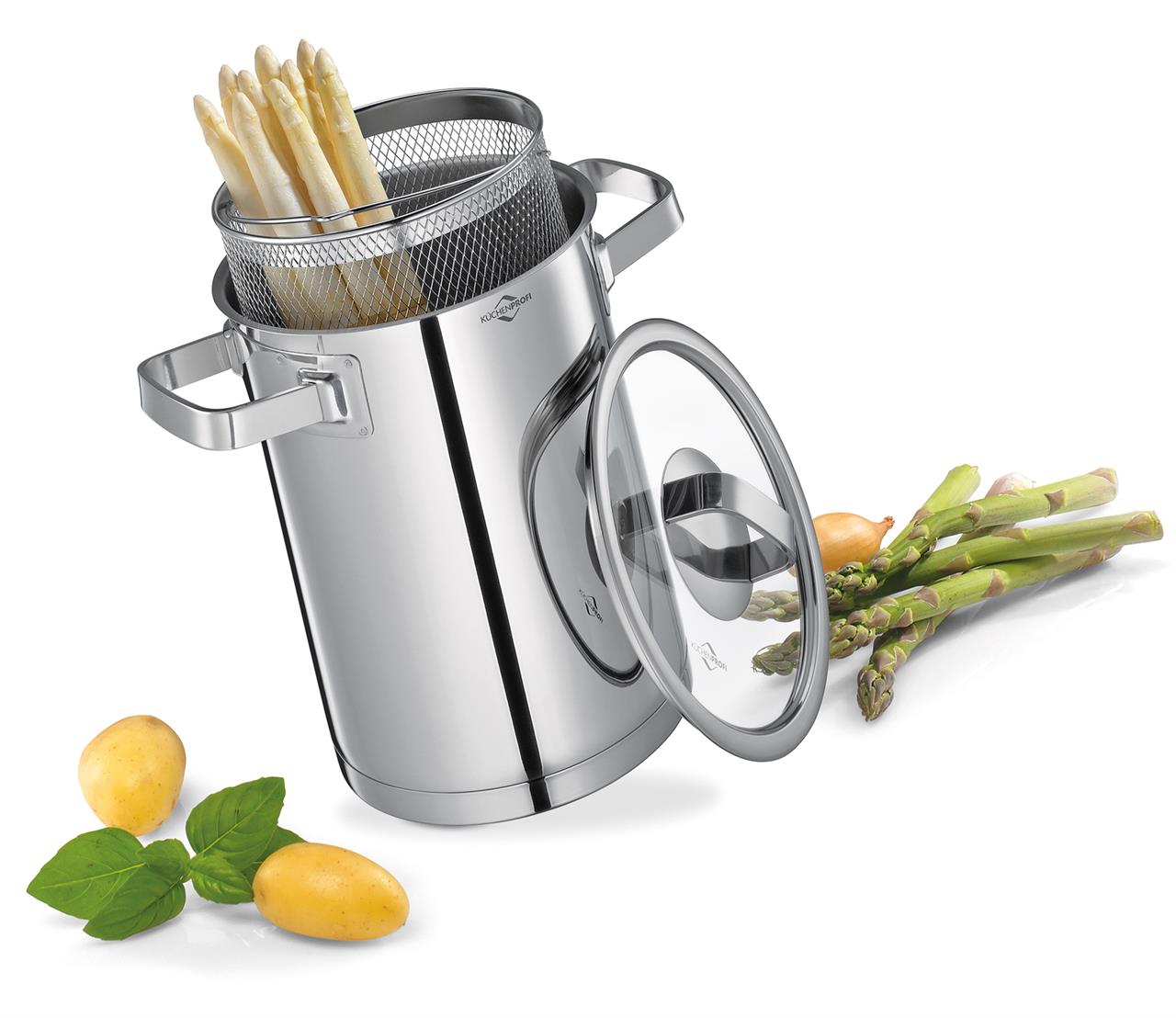 Der Spargeltopf San Remo aus Edelstahl ist mit einem Einsatz zum Kochen von Spargel ausgestattet. Neben dem Topf liegen Kartoffeln, Basilikumblätter und frischer grüner Spargel.
