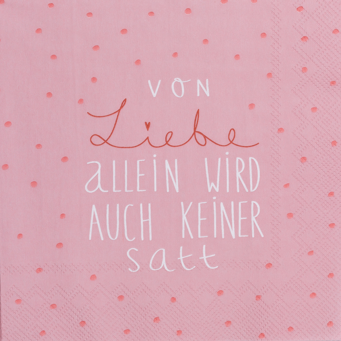 Das Bild zeigt eine rosafarbene Serviette mit kleinen Punkten. Darauf steht der Text: "Von Liebe allein wird auch keiner satt."