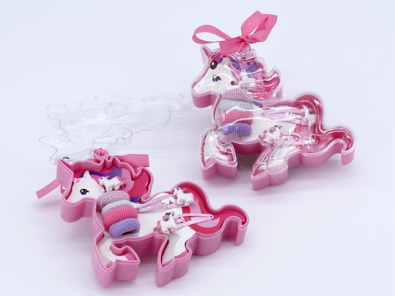 Die Geschenkbox Einhorn 7 Teile enthält verschiedene Haaraccessoires in einer pinken Einhorn-Box. Die Box ist durchsichtig und mit einer Schleife verziert.