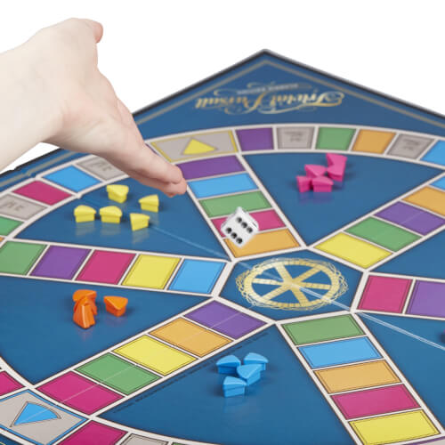 Auf dem Bild sieht man ein Brettspiel mit bunten Spielfiguren und einem Würfel. Eine Hand wirft gerade den Würfel auf das Spielfeld.