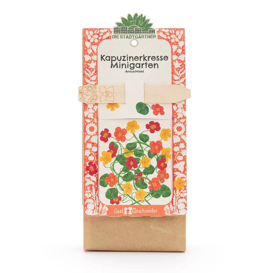 Das Bild zeigt das Produkt "Saatgeschwister Minigarten Kapuzinerkresse (Bio)". Die Verpackung ist bunt gestaltet und zeigt eine Illustration der Kapuzinerkresse in orange, rot und gelb.