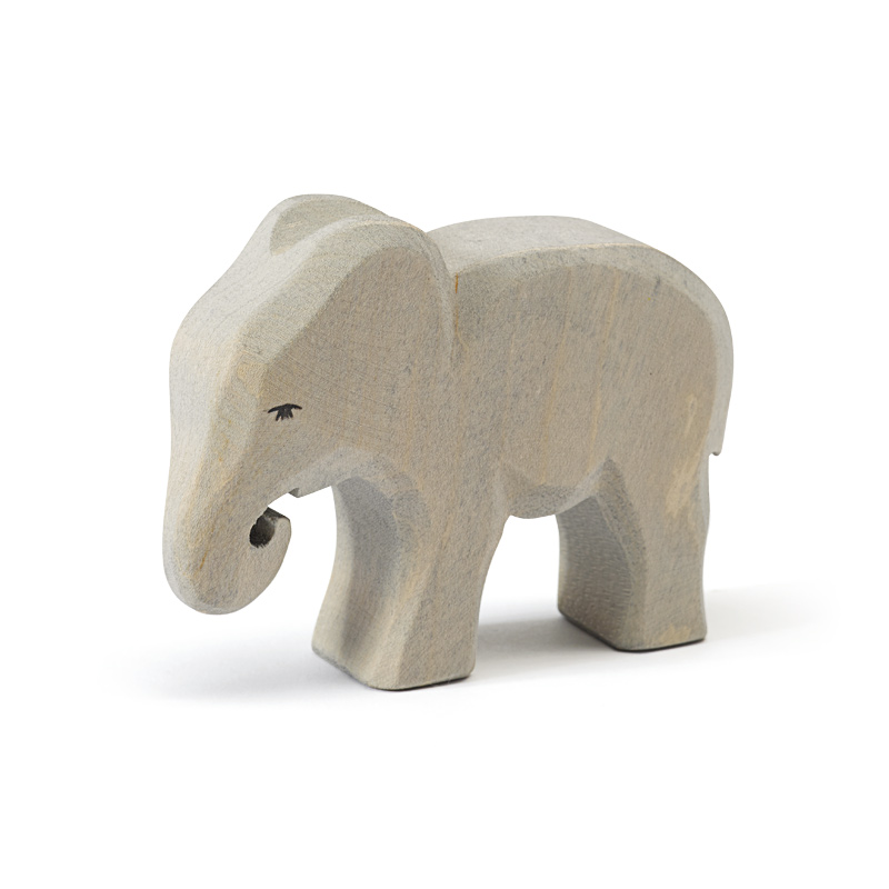 Das Bild zeigt eine kleine, graue Elefantenfigur aus Holz. Der Elefant steht mit leicht gesenktem Kopf und angewinkeltem Rüssel.