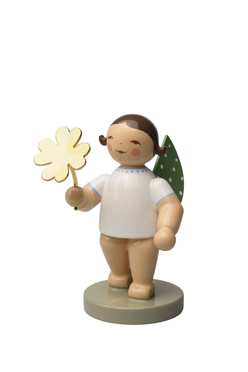 Die Figur zeigt einen Engel mit grünen Flügeln und weißen Punkten, der ein vergoldetes Kleeblatt in der Hand hält. Der Engel steht auf einem runden Sockel und trägt ein weißes Kleid.