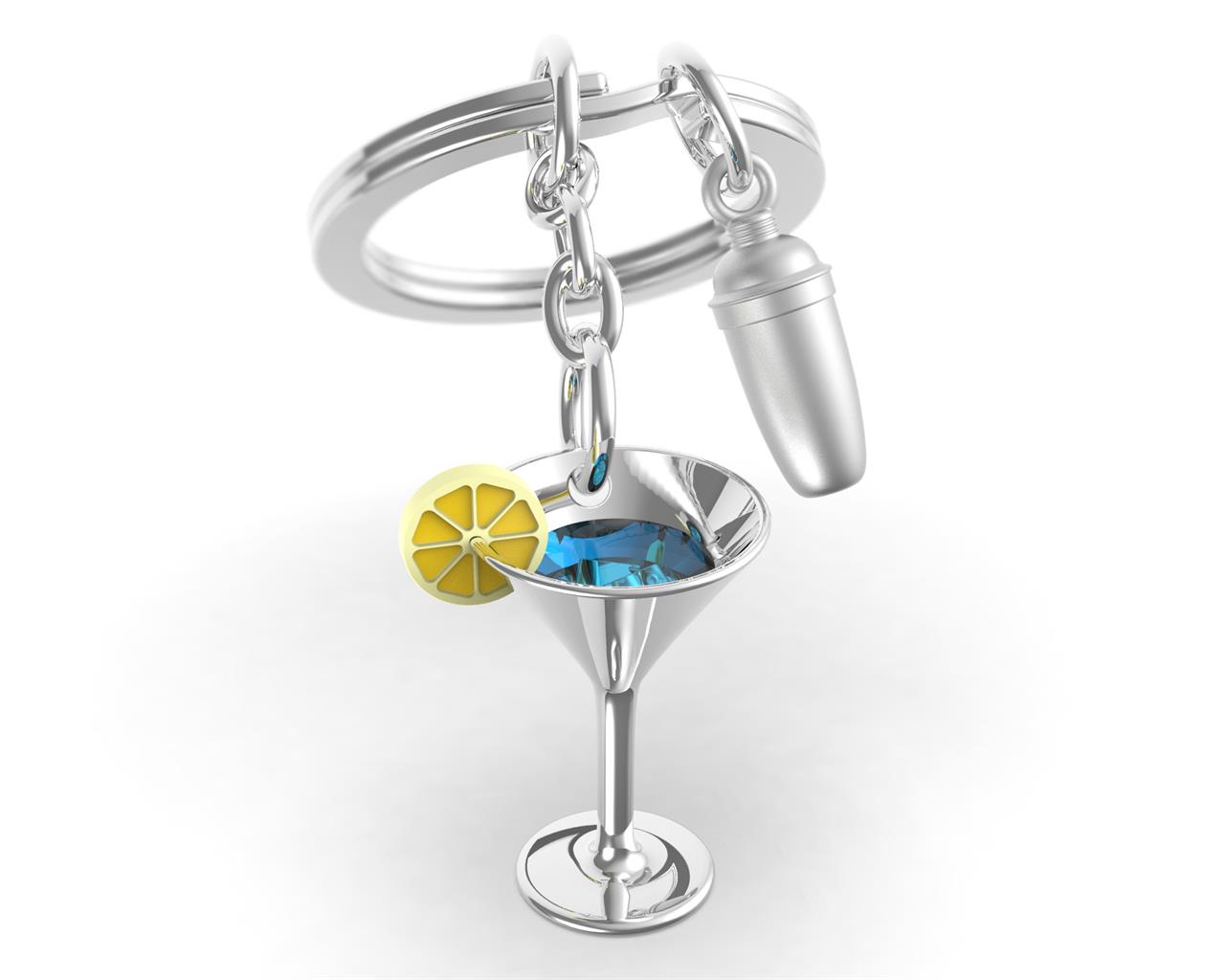 Der Schlüsselanhänger zeigt einen silbernen Cocktailglas-Anhänger mit einer blauen Flüssigkeit und einer Zitronenscheibe. Daneben hängt ein kleiner silberner Cocktailshaker am Schlüsselring.