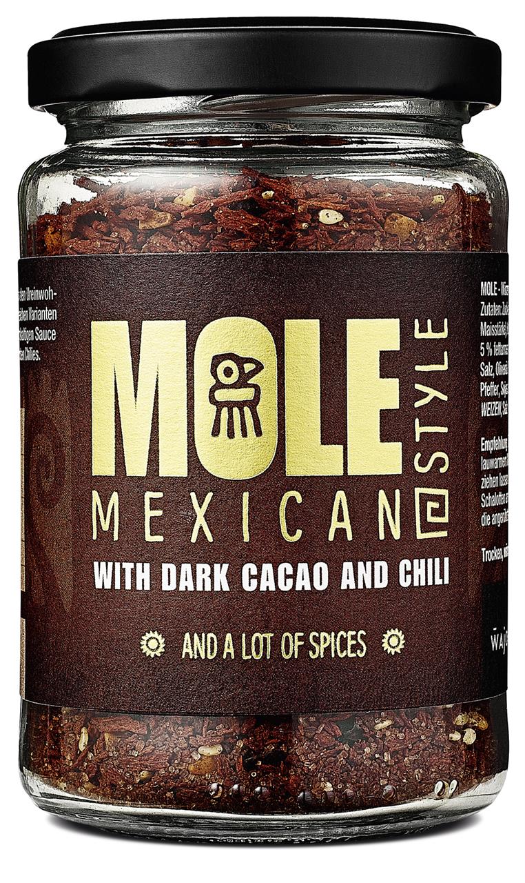 Das Bild zeigt ein Glas mit dem Produkt "Mole – Mexikanische Sauce mit dunklem Kakao und Chili, 120g". Auf dem Etikett steht außerdem, dass die Sauce viele Gewürze enthält.