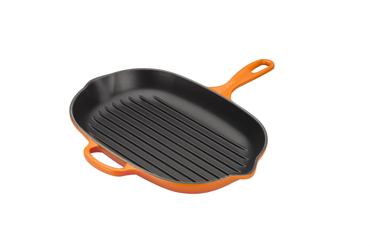 Die Abbildung zeigt eine ovale Grillpfanne mit gerillter Oberfläche. Die Pfanne ist außen orange (Ofenrot) und hat einen Griff sowie einen kleinen Gegengriff.