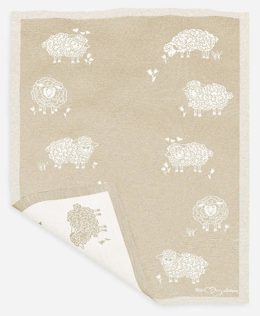 Das Bild zeigt ein naturfarbenes Halbleinen-Geschirrtuch mit weißen Schafmotiven. Das Tuch ist 45x73 cm groß und hat ein einfaches, ländliches Design.