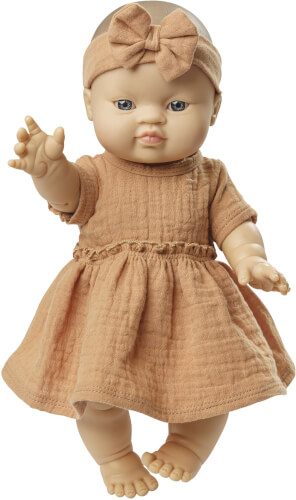 Die Puppe trägt ein beigefarbenes Kleid und ein passendes Stirnband mit Schleife. Sie hat blaue Augen und streckt einen Arm nach vorne aus.
