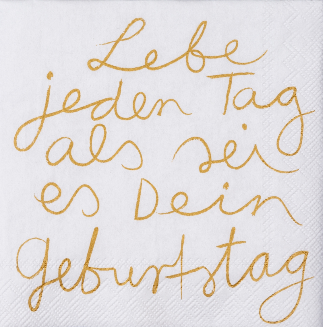Die Serviette zeigt den Spruch „Lebe jeden Tag als sei es dein Geburtstag“ in goldener Handschrift. Sie ist weiß und misst 25 cm x 25 cm.
