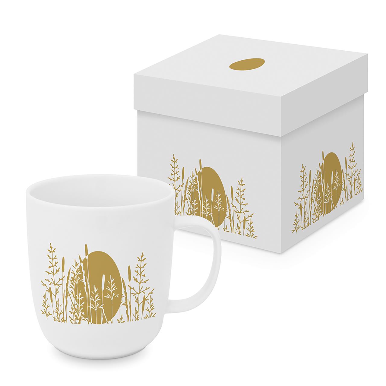 Auf dem Bild ist eine weiße Tasse mit einem goldenen Osterei und Gräsern abgebildet. Die Tasse steht vor einer passenden Geschenkbox mit dem gleichen Design.