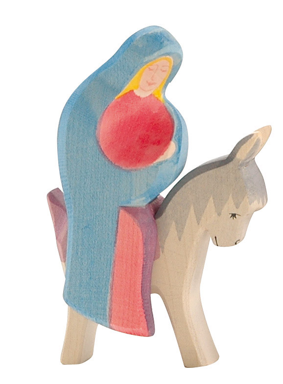 Die Abbildung zeigt eine Holzfigur von Maria auf einem Esel. Die Figur ist bunt bemalt und besteht aus zwei Teilen.