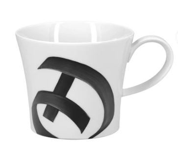 Auf dem Bild ist eine weiße Tasse mit einem großen, schwarzen Buchstaben „D“ zu sehen. Die Tasse gehört zur "Becher Berlin D Alphabet Edition".