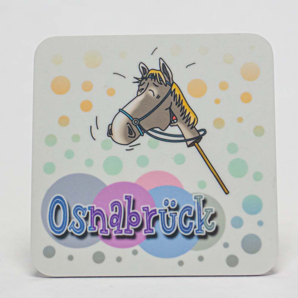 Das Bild zeigt einen Untersetzer mit einem gezeichneten Steckenpferd und bunten Punkten im Hintergrund. Unten steht in großen Buchstaben "Osnabrück".