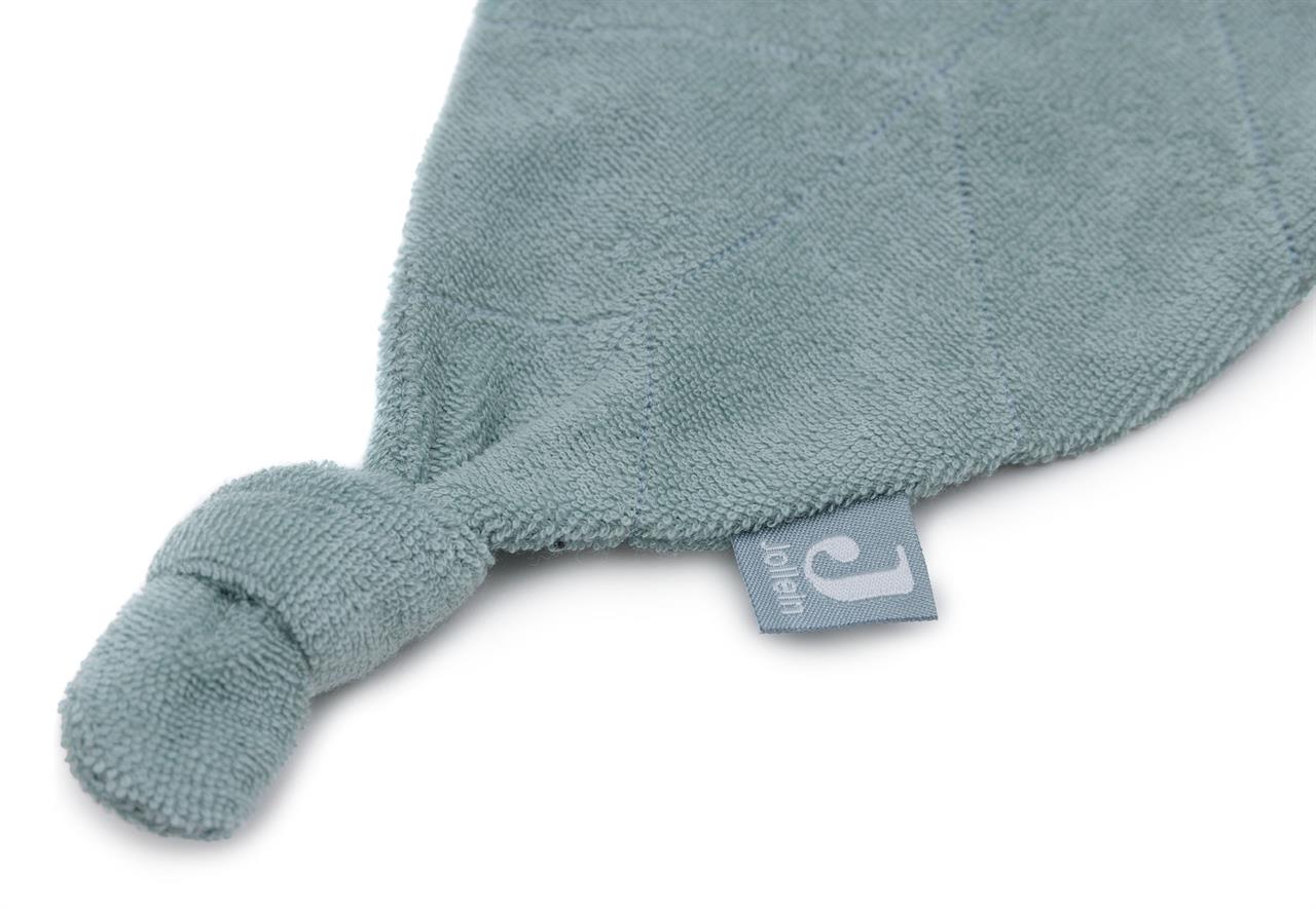 Das Bild zeigt ein Schmusetuch aus Frottee in der Farbe Sea Green. An einer Ecke ist ein Knoten gebunden und ein kleines Etikett angebracht.