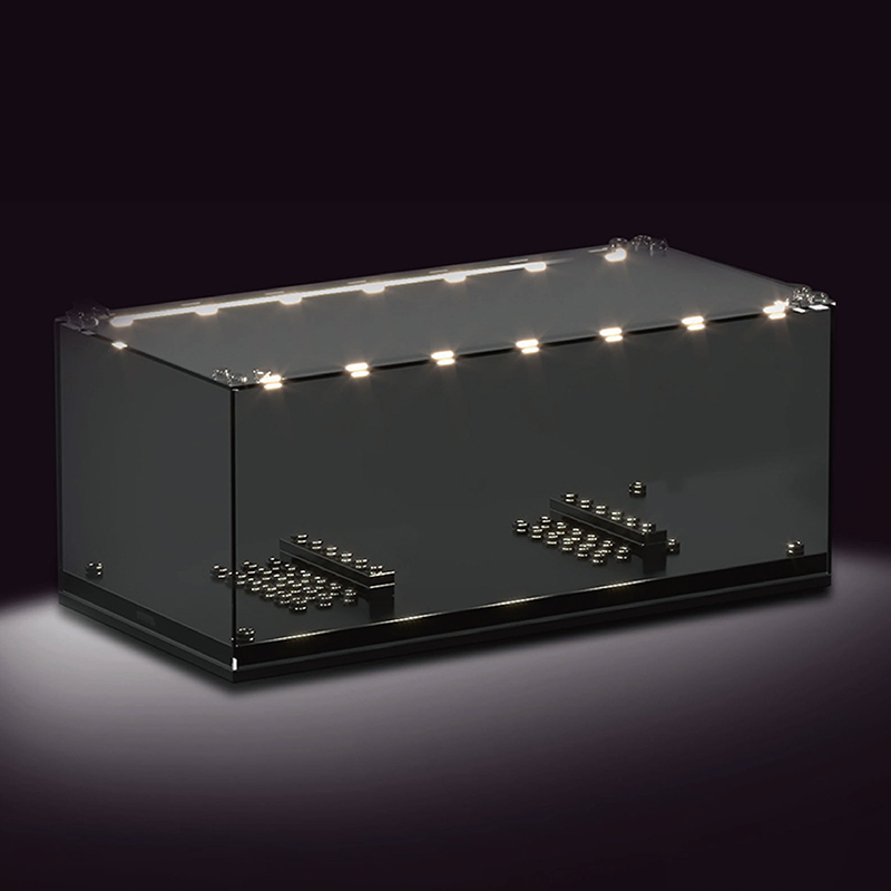 Die Abbildung zeigt die Mould King® 27000 Minicar Lighting Showcase, eine beleuchtete Vitrine. Das Gehäuse ist durchsichtig und enthält innen kleine Bauplatten zur Präsentation von Modellautos.