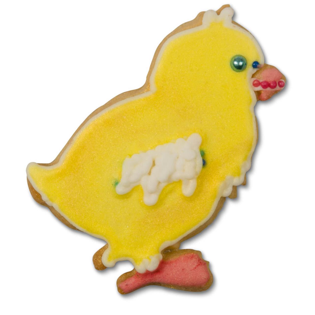 Auf dem Bild ist ein Keks in Form eines Kükens zu sehen, der bunt verziert ist. Das Produkt heißt „Ausstecher, Küken 6,5 cm“.