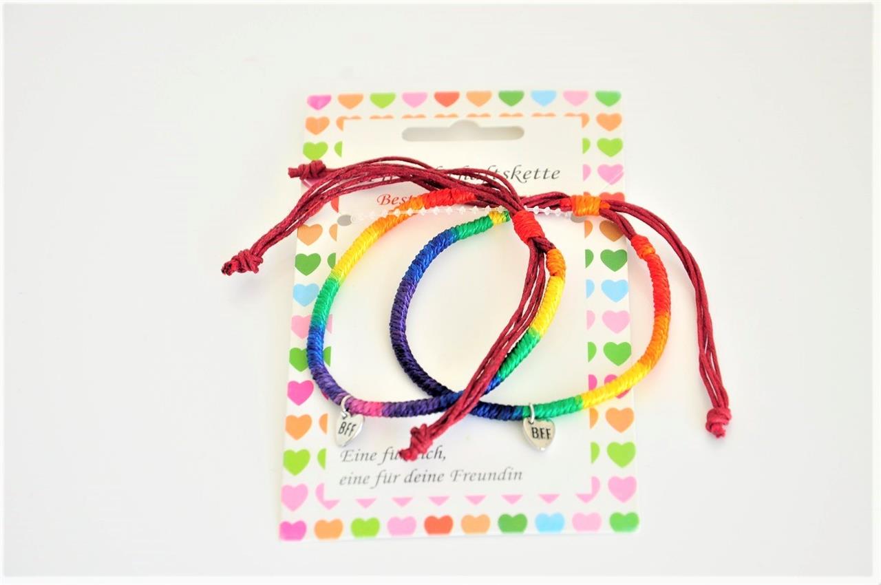 Das Bild zeigt zwei bunte Regenbogen-Armbänder mit der Aufschrift "BFF" auf kleinen Anhängern. Die Armbänder liegen auf einer Karte mit bunten Herzen.
