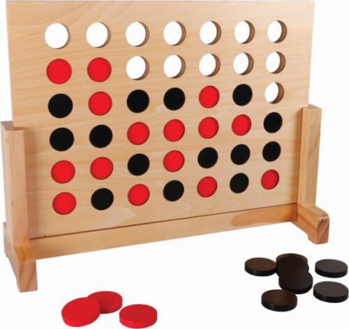 Auf dem Bild ist ein Holzspiel "Vier gewinnt" mit roten und schwarzen Spielsteinen zu sehen. Einige Spielsteine liegen noch neben dem Spielfeld.