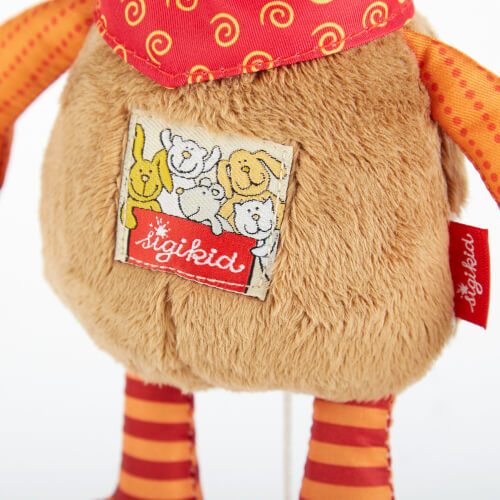 Das Bild zeigt den Bauch eines plüschigen Stofftiers mit einem roten Halstuch mit gelben Spiralen. Auf dem Bauch ist ein Patch mit Zeichnungen von Tieren und dem Schriftzug "sigikid" zu sehen.