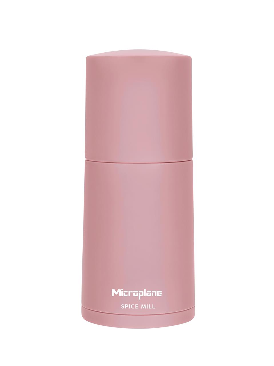 Auf dem Bild ist eine altrosa Gewürzmühle aus der Color Edition zu sehen. Die Mühle hat ein schlichtes, modernes Design und trägt die Aufschrift "Microplane Spice Mill".