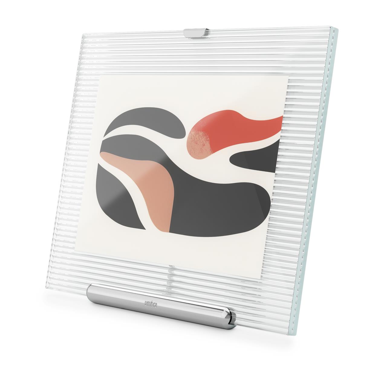 Der FLUTE Bilderrahmen 13x18 Chrom zeigt ein modernes, geriffeltes Design aus klarem Glas mit einem Rahmen in Chromoptik. Er präsentiert stilvoll ein abstraktes Kunstwerk in Schwarz-, Orange- und Rottönen.