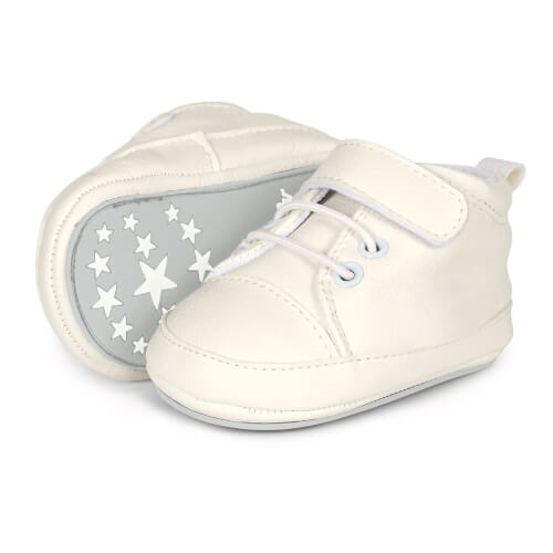 Auf dem Bild sind zwei weiße Babyschuhe zu sehen. Die Sohle eines Schuhs ist mit Sternmotiven verziert.