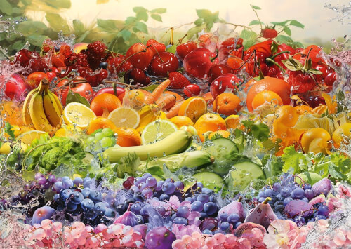 Das Bild zeigt eine bunte Auswahl verschiedener Früchte, darunter Bananen, Trauben, Zitronen, Kirschen und Orangen. Über den Früchten spritzt Wasser, was die Frische betont.