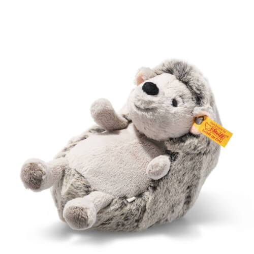 Dieses Bild zeigt ein kuscheliges Stofftier in Form eines Igels. Der Igel hat ein weiches, graues Fell und eine gelbe Marke am Ohr.