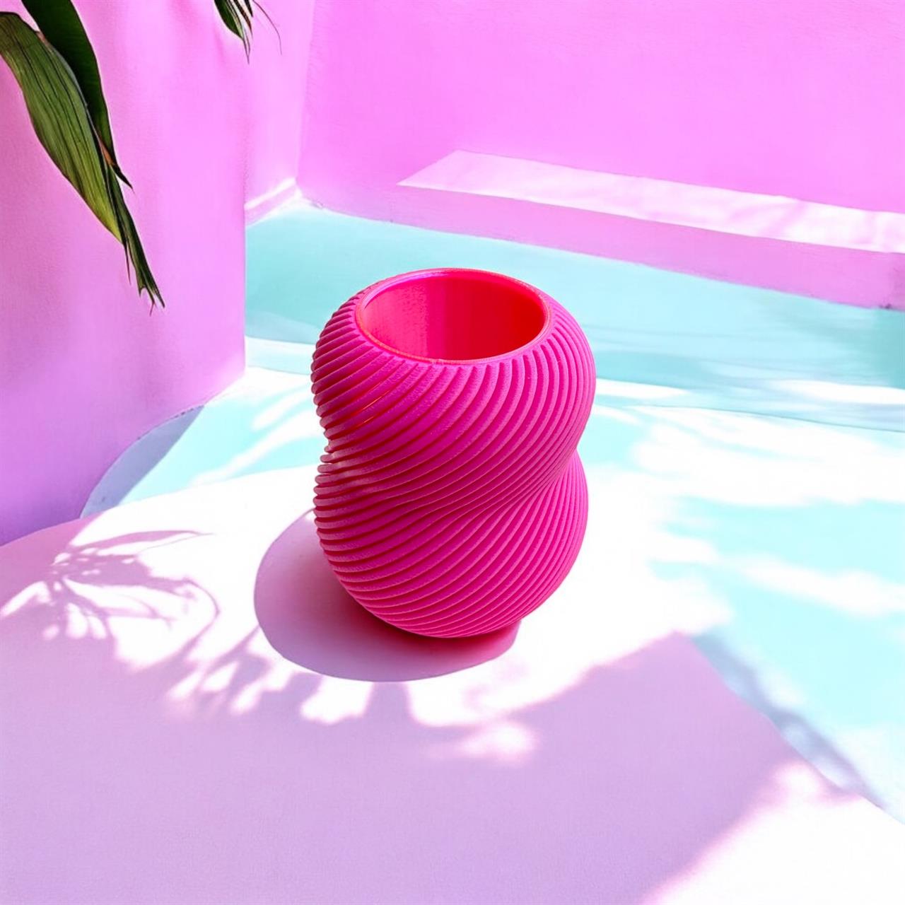 Auf dem Bild ist eine Vase mit dem Namen "Vase Bloom 100% 'Magenta'" zu sehen. Die Vase hat eine kräftige magentafarbene Farbe und steht in einer hellen, modernen Umgebung.